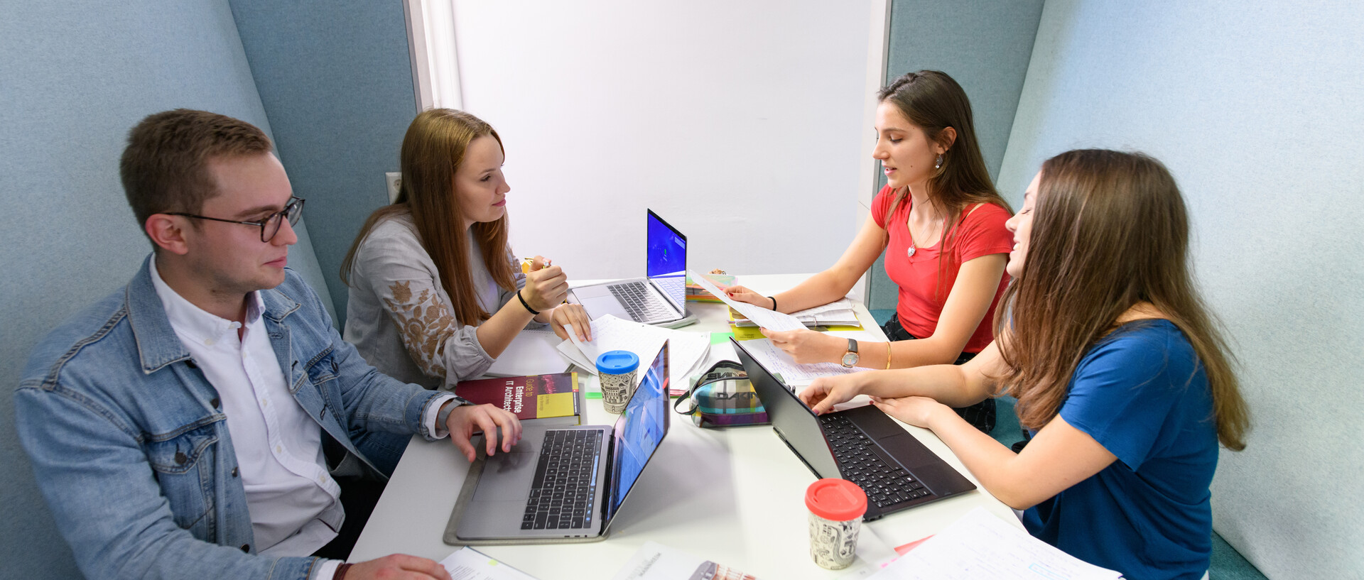 Vier Studierende arbeiten zusammen in der Unibibliothek
