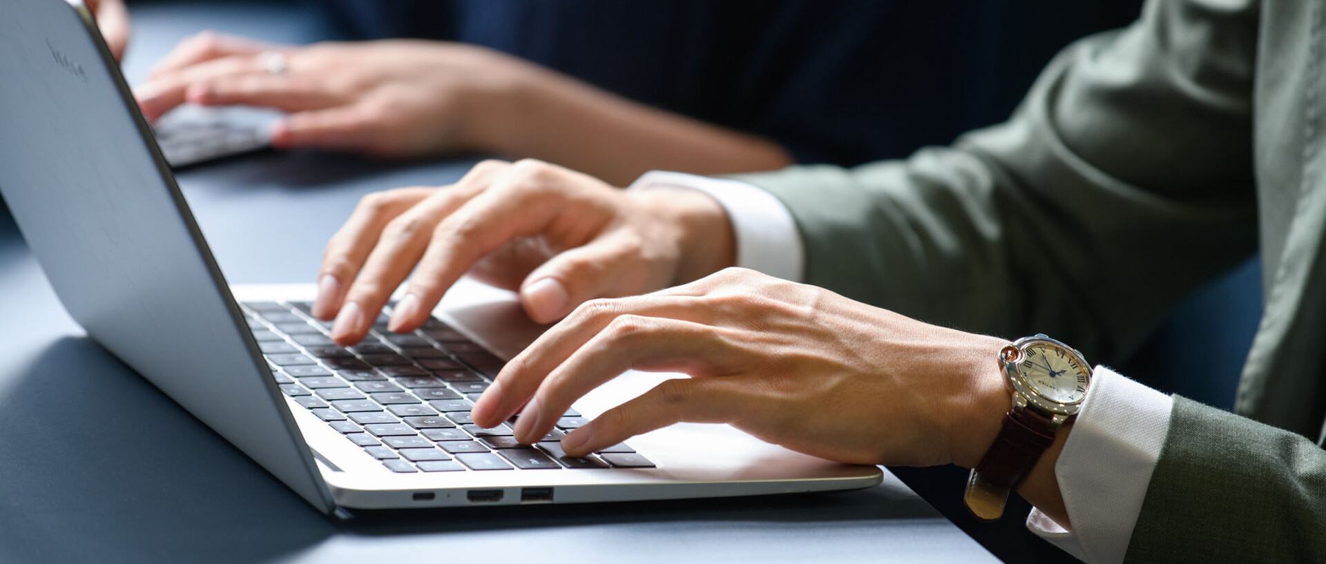 Hände einer Person, die am Laptop arbeitet