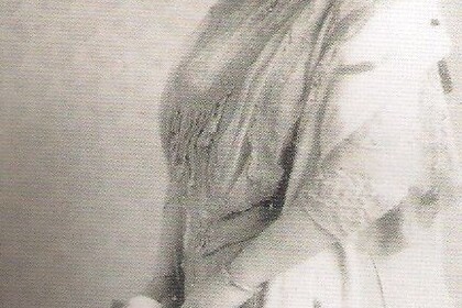 Schwarz-weiß-Abbildung von Julie Bassermann. Sie ist von der Seite zu sehen, trägt einen dunklen Hut und ein langes Kleid.