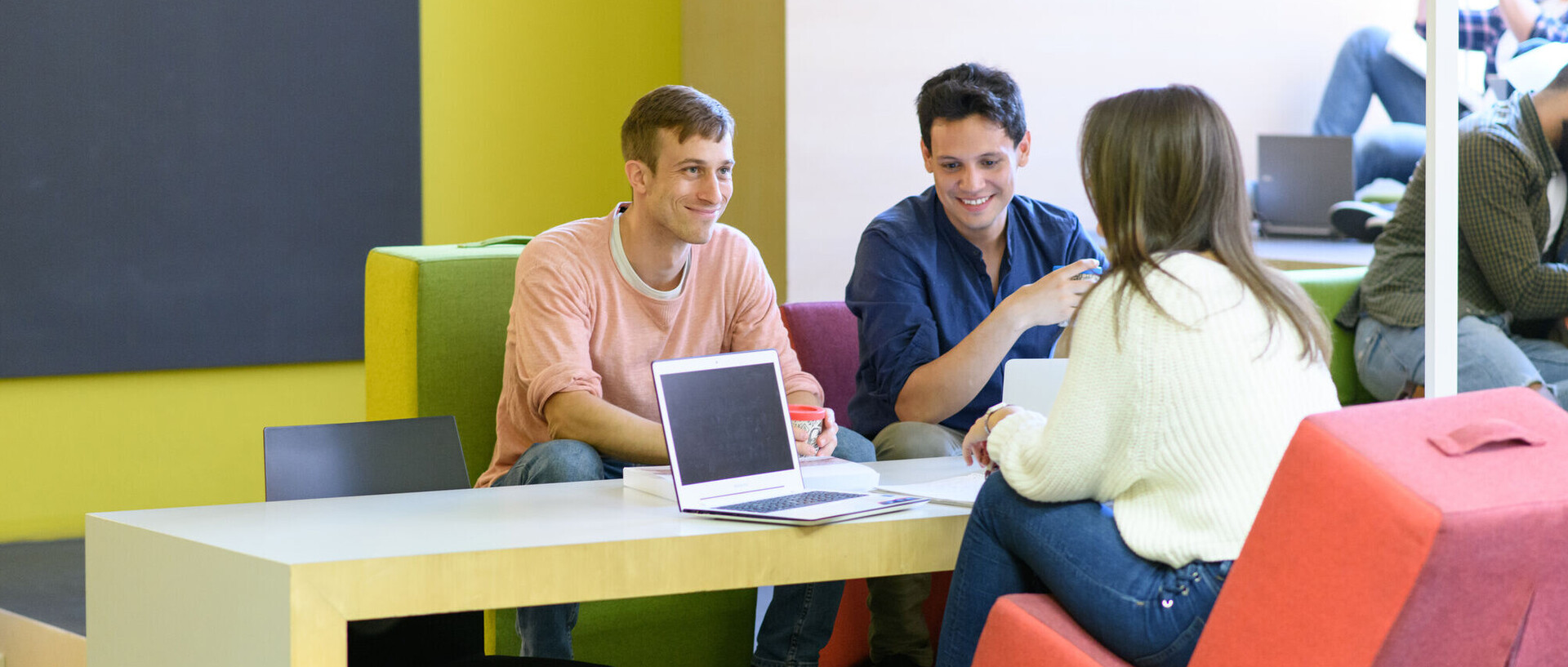 Drei Studierende sitzen an einem Arbeitsplatz im Learning Center.