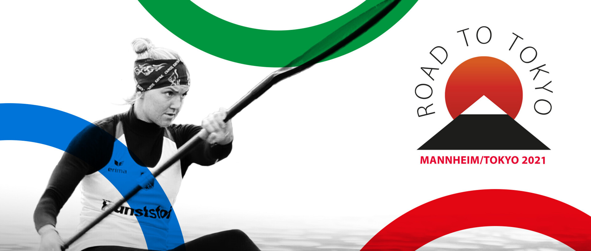 Schwarz-Weißes Bild mit Frau auf dem Wasser in einem Kanu und mit einem Padel in den Händen. Eventuell nimmt sie an einem Wettbewerb teil. Oben links steht "Road to Tokyo - Mannheim/Tokyo 2021". Drei Olympiaringe abgeschnitten an Rändern des Bildes.