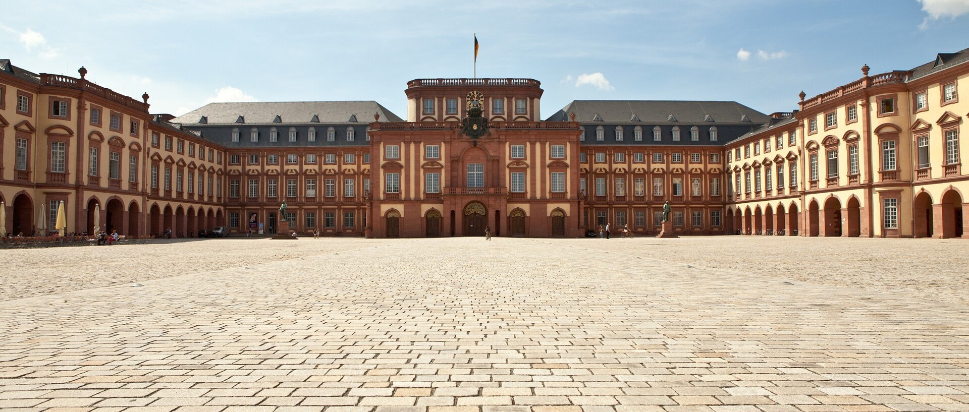 Das Mannheimer Barockschloss und der Ehrenhof bei blauem Himmel.
