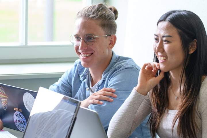 Dual Studierende sitzen gemeinsam am Tisch