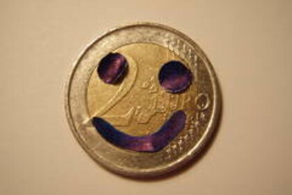 Zwei-Euro-Münze auf die ein Smiley gemalt wurde.