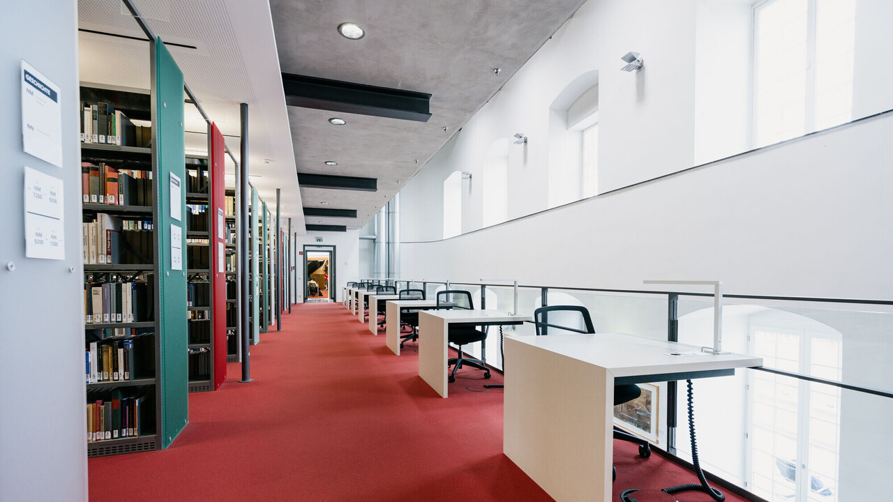 Bibliotheksgang mit Einzelarbeitsplätzen und rotem Teppich