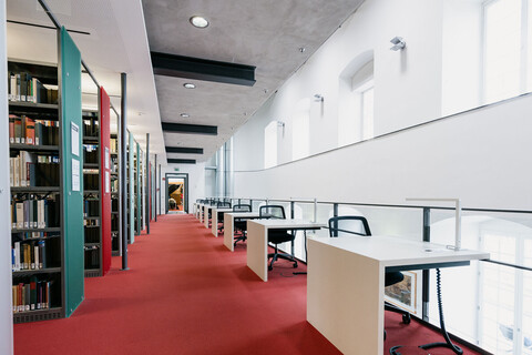 Bibliotheksgang mit Einzelarbeitsplätzen und rotem Teppich