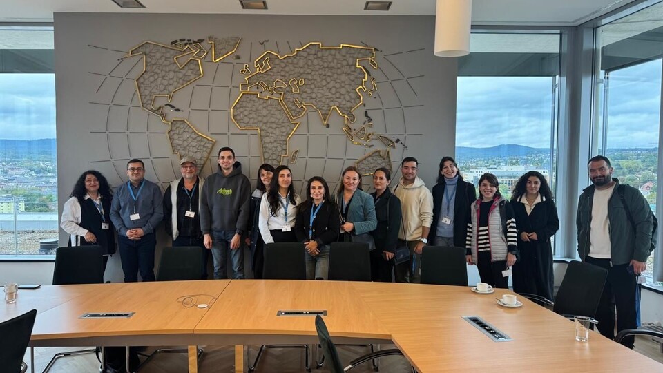 Group of cooperation partners from Eastern European countries in front of a large world map at the Federal Statistical Office