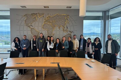 Group of cooperation partners from Eastern European countries in front of a large world map at the Federal Statistical Office 