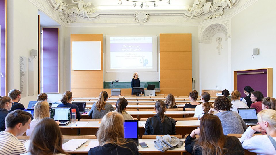 Studierende hören bei einer Vorlesung zu.