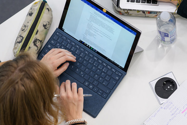 Eine Studentin sitzt an ihrem Laptop und lernt.