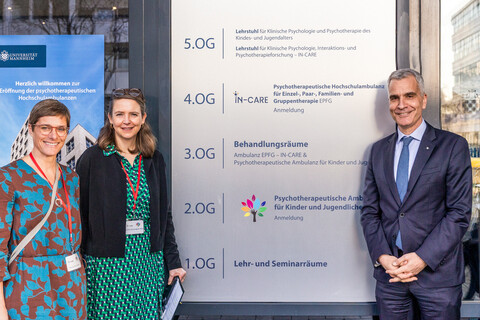 Die beiden Leiterinnen der Ambulanzen und der Rektor der Universität stehen neben dem Eingangsschild