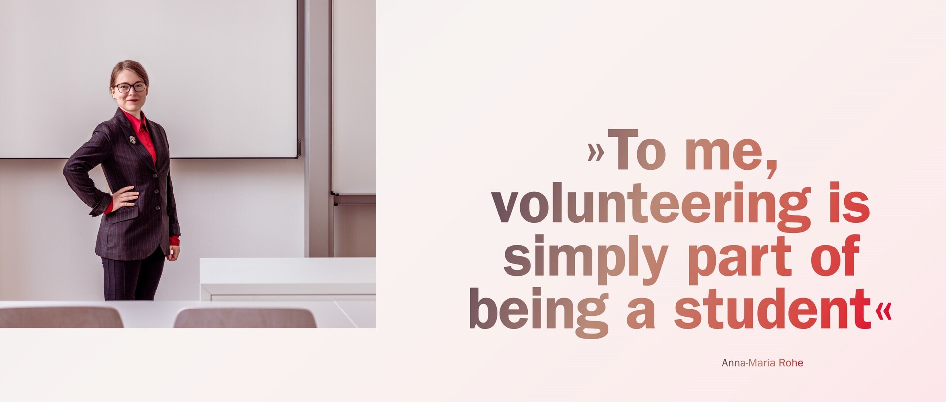 Anna-Maria Rohe stands next to a table in a seminar room at the university. Next to her is a quote by Rohe: “To me, volunteering is simply part of being a student”