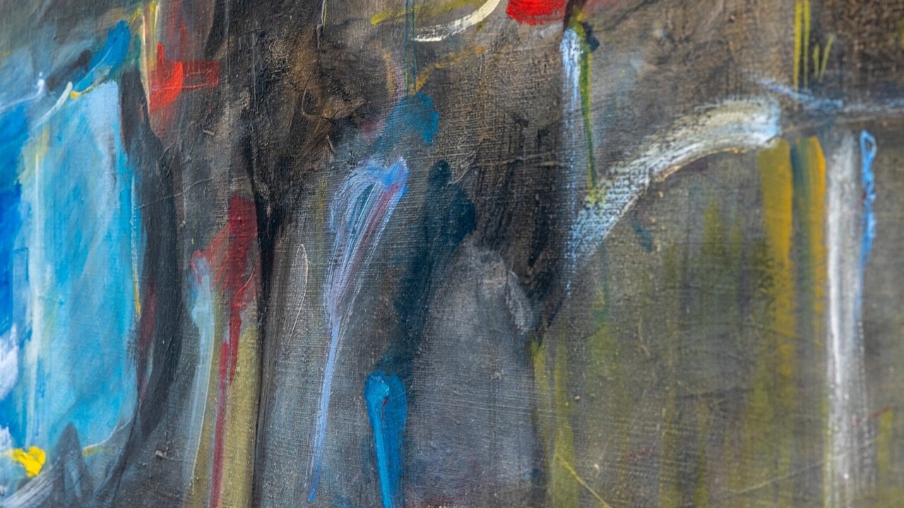Eingezoomter Ausschnitt eines abstrakten Gemäldes mit grauem Unterton und Akzenten in blau, rot und gelb.