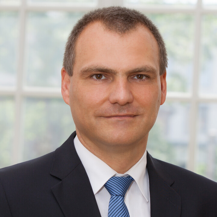 Prof. Dr. Dirk Simons im schwarzen Anzug und blaugestreifter Krawatte