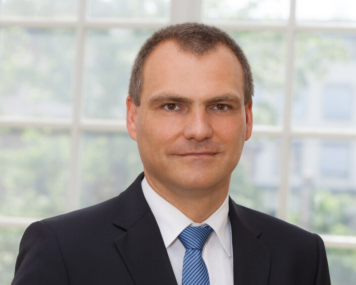 Prof. Dr. Dirk Simons im schwarzen Anzug und blaugestreifter Krawatte