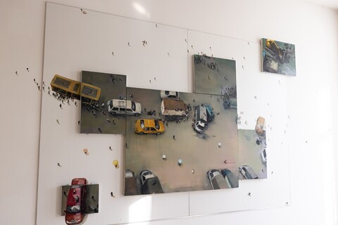 Gemälde einer Person mit Miniaturfiguren, das sich auf die Wand fortsetzt. An einer Stelle sind Autos, Figuren und ein Verkehrschaos mit Unfall dargestellt