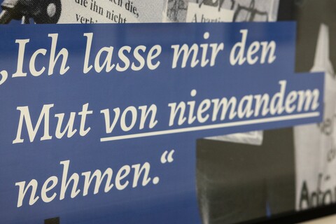 Nahaufnahme einer Informationstafel mit der Aufschrift "Ich lasse mir den Mut von niemandem nehmen."
