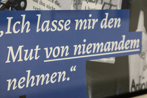 Nahaufnahme einer Informationstafel mit der Aufschrift "Ich lasse mir den Mut von niemandem nehmen."