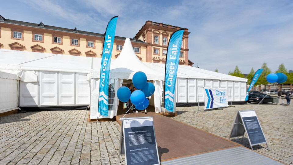 Messezelt auf dem Ehrenhof. Fahnen neben dem Eingang mit der Aufschrift Career Fair.