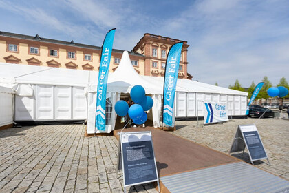 Messezelt auf dem Ehrenhof. Fahnen neben dem Eingang mit der Aufschrift Career Fair.