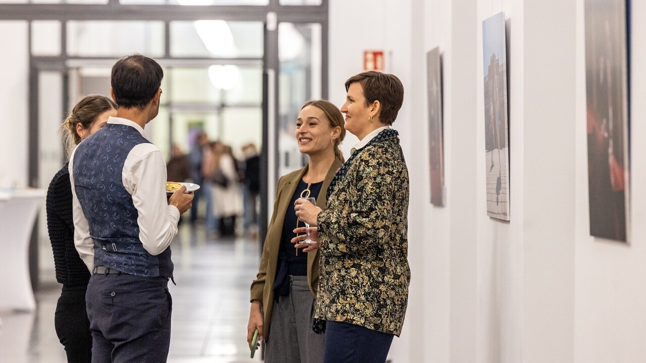 Vier Personen stehen vor den Bildern der Spitzensport-Vernissage.
