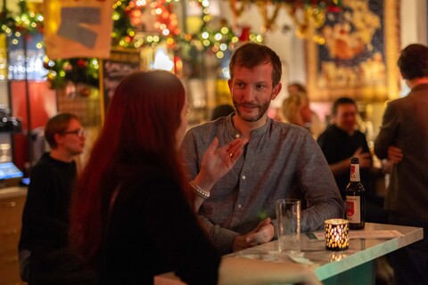 Zwei Personen unterhalten sich in einer Bar.
