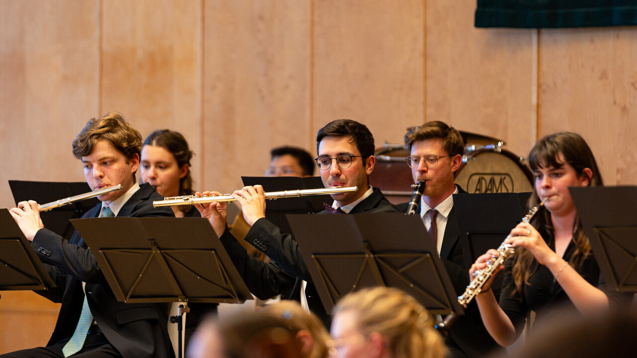 Auftritt des Uniorchesters. Studierende sind schwarz gekleidet und spielen jeweils ein Instrument