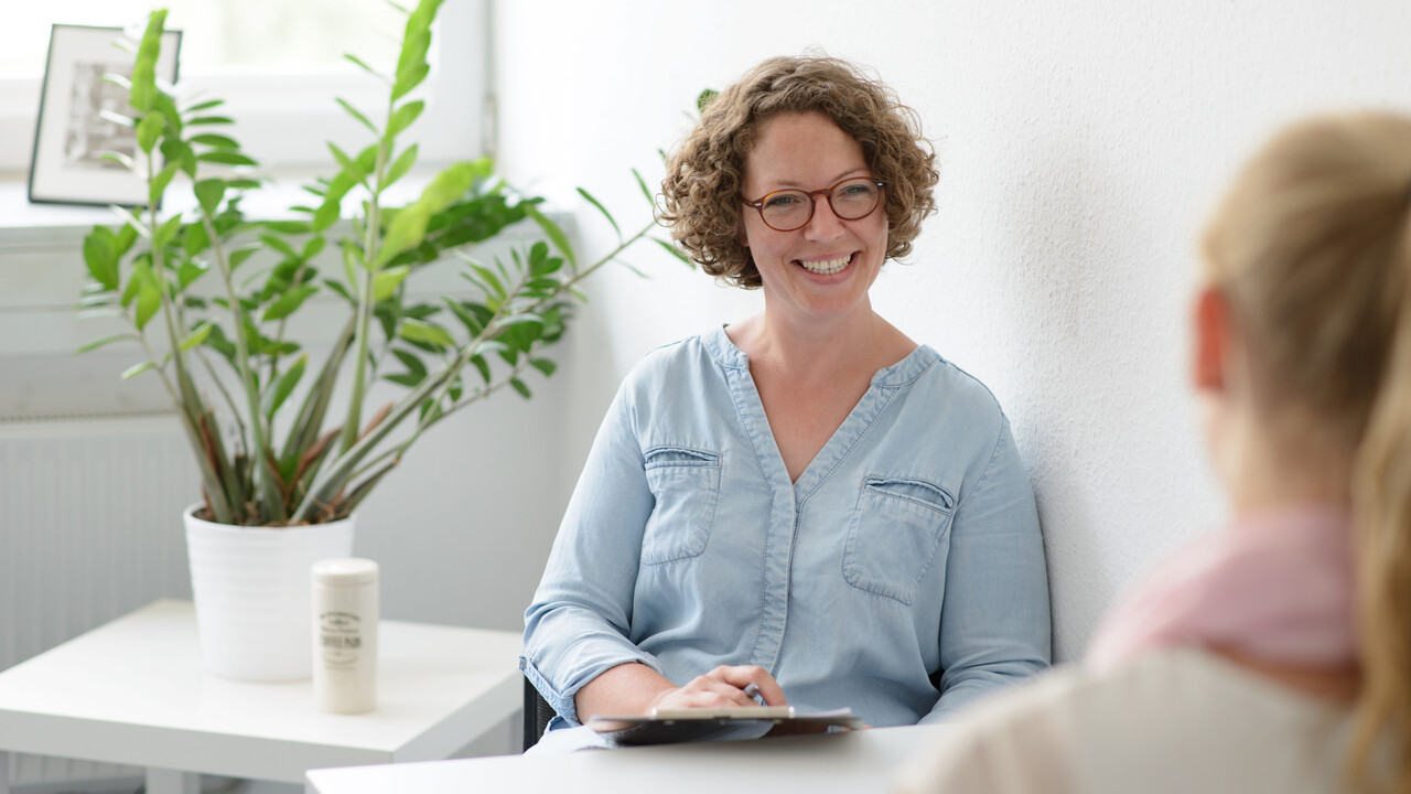Beraterin sitzt mit einer zweiten Person am Tisch