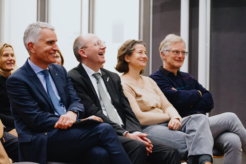 Das Foto zeigt vier Personen in der ersten Reihe der Zuhörenden. Sie lachen. Es sind der Rektor der Universität Mannheim, der Oberbürgermeister der Stadt Mannheim, die Kanzlerin der Universität Mannheim, ein ehemaliger Rektor der Universität Mannheim