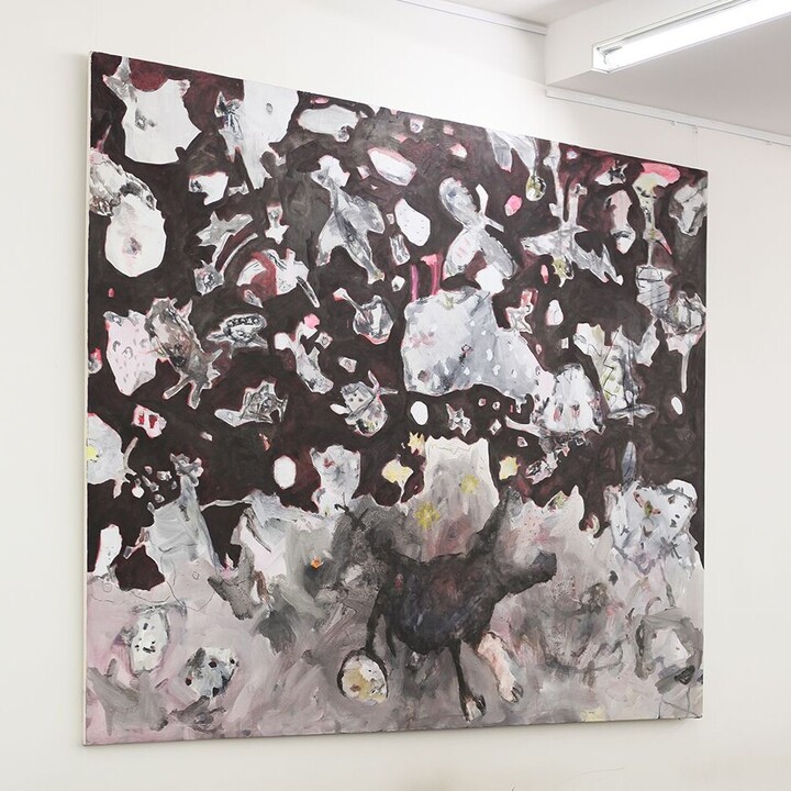 Die Aufenthaltsfläche im Schneckenhof Ost mit braunen Tischen und einem Bild an der Wand, das zahlreiche kleine und mittelgroße Wesen und Gegenstände zeigt  