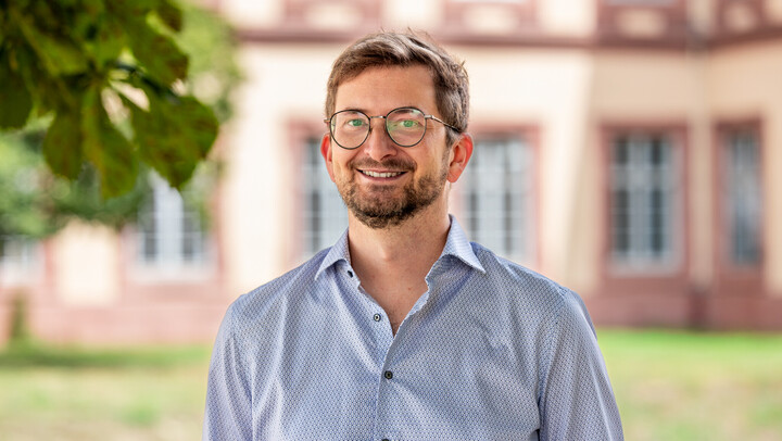 Porträtbild von Dr. Philipp Müller vor dem Mannheimer Schloss.