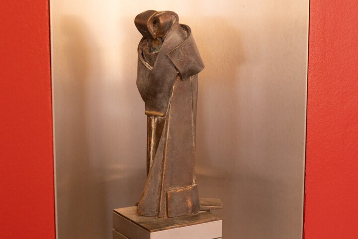 Ein Statue zweier sich umarmender Menschen in einer Wandnische