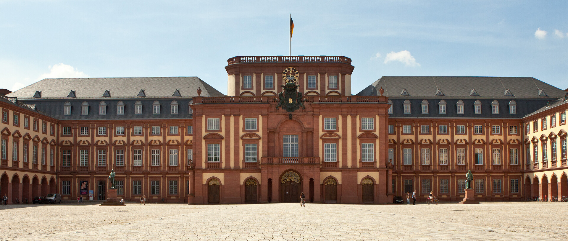 Das Mannheimer Barockschloss und der Ehrenhof unter blauem Himmel.