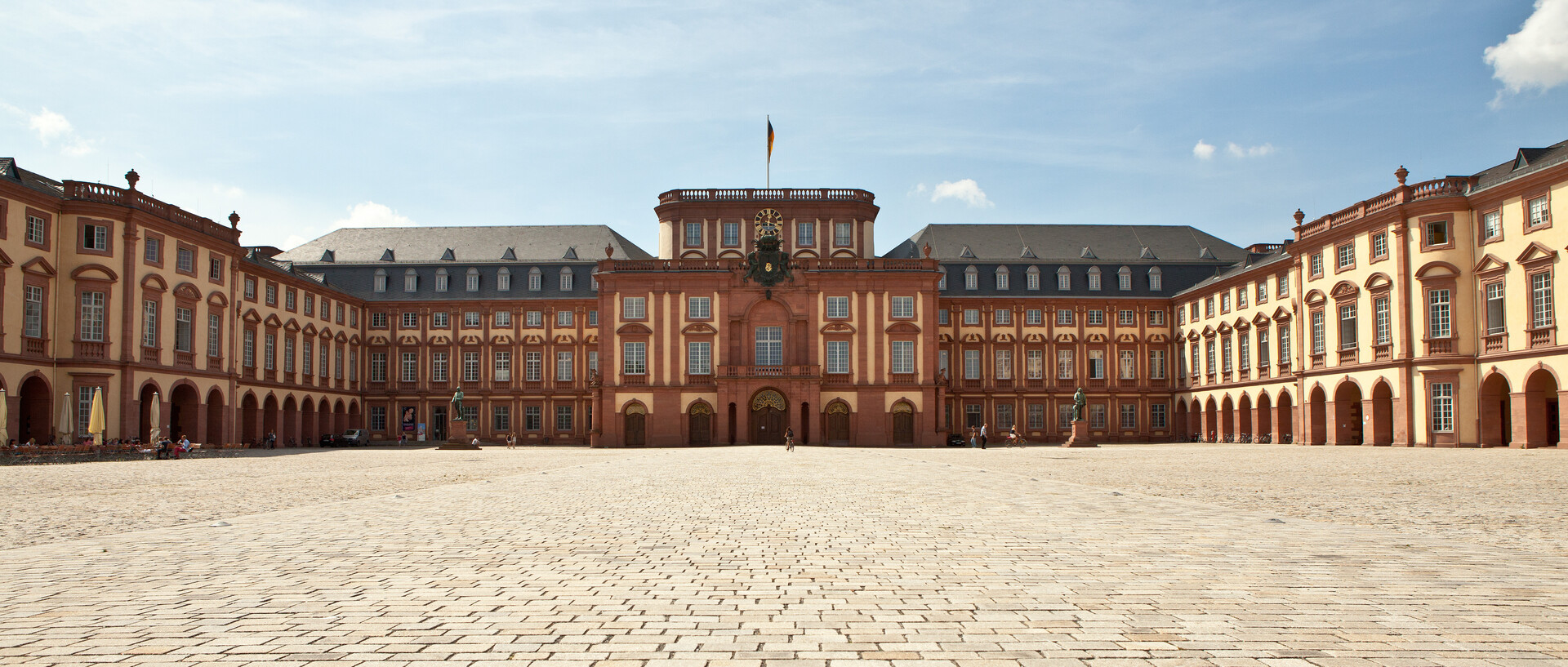 Das Mannheimer Barockschloss und der Ehrenhof unter blauem Himmel.