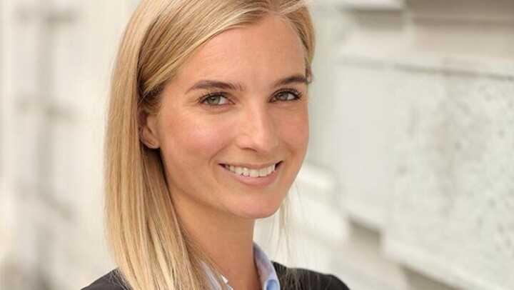 Lina Übbing hat lange blonde Haare. Sie trägt eine helles Hemd und einen schwarzen Blazer.