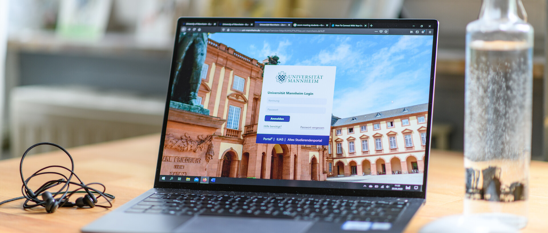Aufgeklappter Laptop auf einem Schreibtisch, zu sehen ist die Anmeldemaske des ILIAS der Universität Mannheim