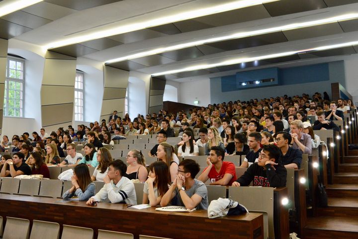 Studierende sitzen in einem vollen Hörsaal.