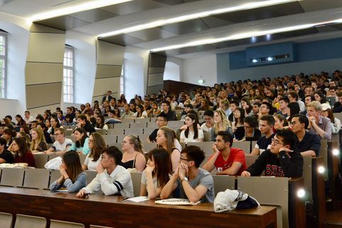 Studierende sitzen in einem vollen Hörsaal.