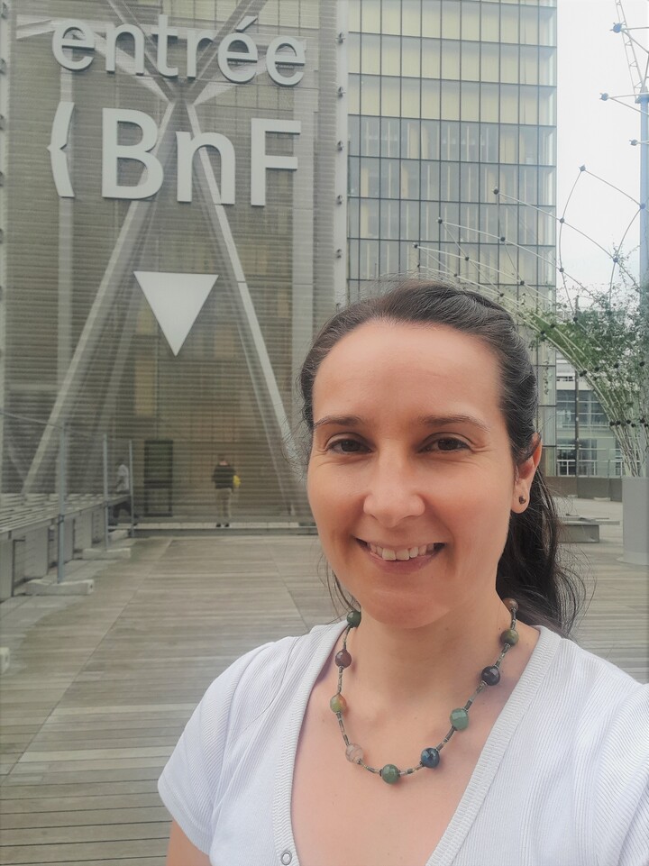 Eine Person trägt ein weißes T-Shirt und steht vor einem Gebäude. Die Person heißt Daniela Kuschel.