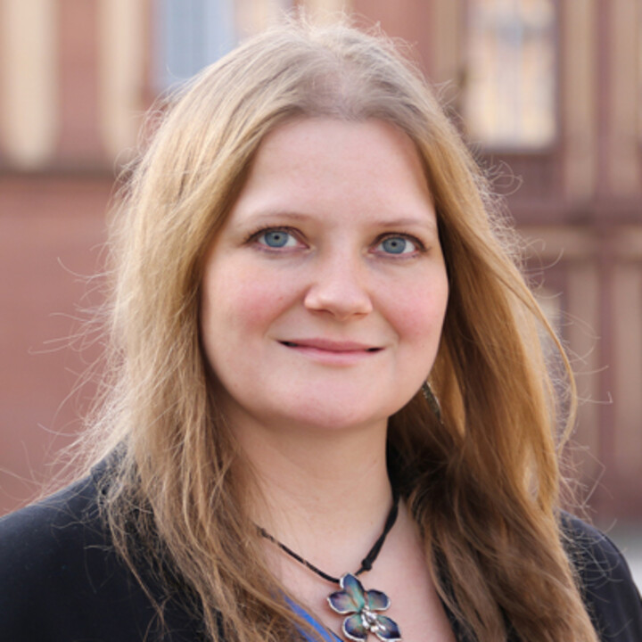 Prof. Dr. Anne Schneider mit blonden langen Haaren im Porträt vor dem Schloss