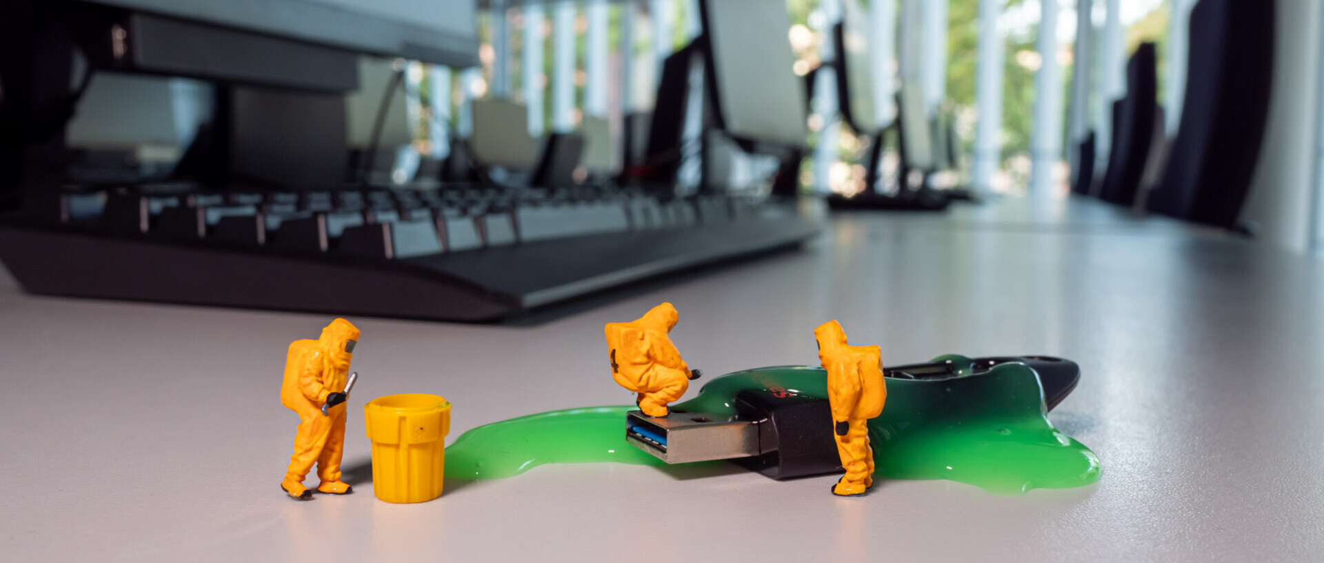 Im PC-Raum der Uni Mannheim befindet sich ein mit Schleim überzogener USB-Stick, der von Minitaurfiguren in Schutzanzügen untersucht wird.