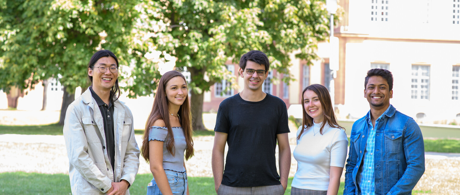 Eine Gruppe Studierender mit dem Mannheimer Schloss im Hintergrund