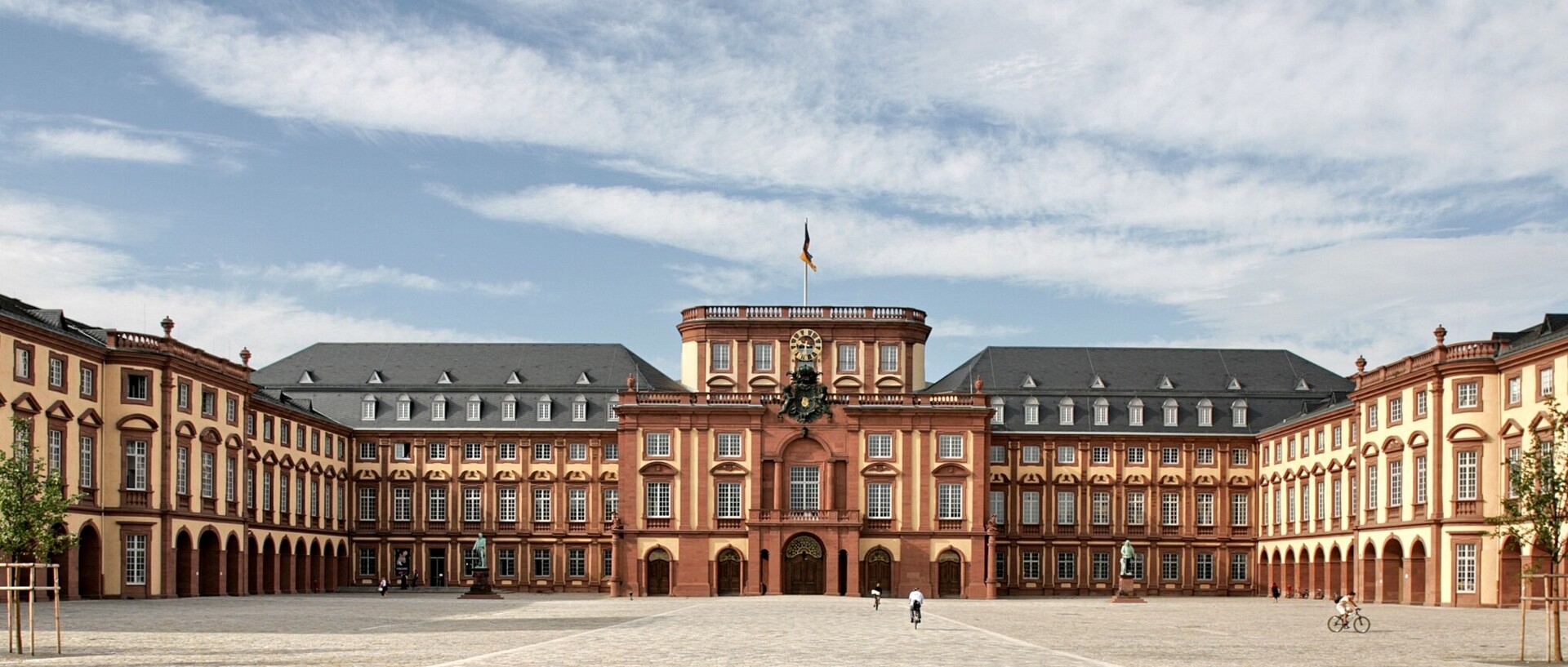 Universität Mannheim mit Ehrenhof an einem sonnigen und bewölkten Tag.