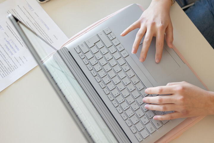 Hands of a person working on a laptop
