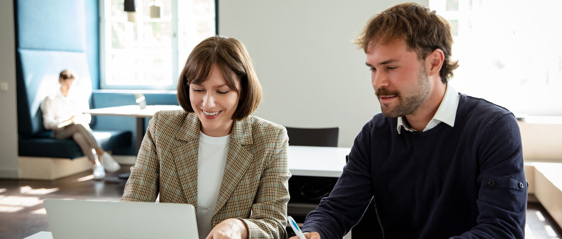 Eine Frau und ein Mann arbeiten zusammen am Laptop. Sie sind beide Forschende der Uni Mannheim.