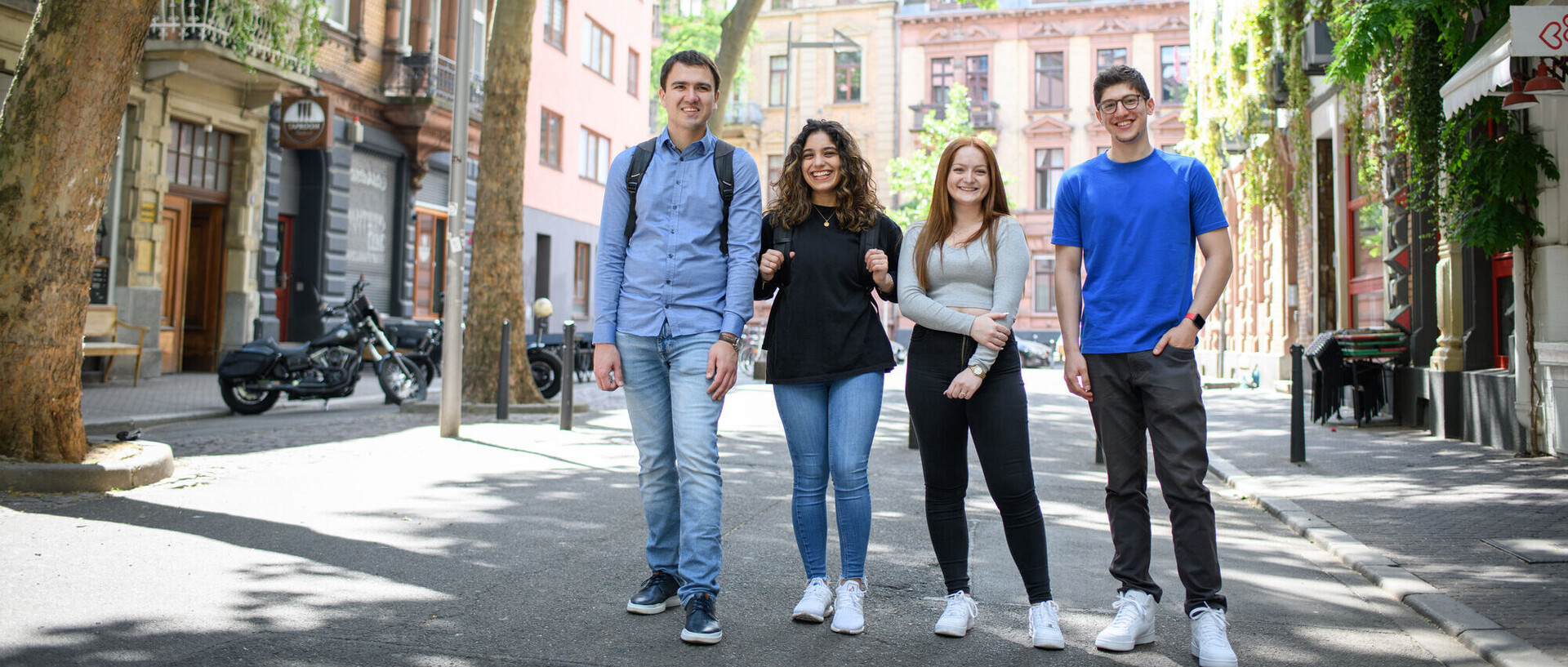 Vier lachende Studierende auf einer verkehrsberuhigten Straße im Mannheimer Jungbusch