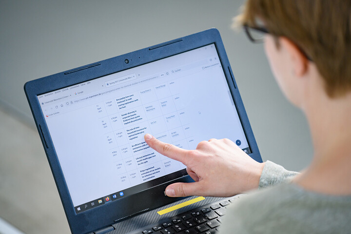 A student watching seminars on a laptop.