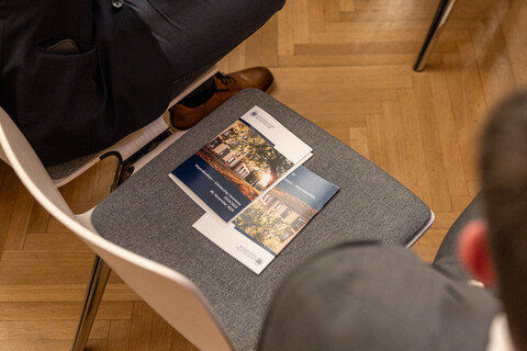 Zwei Broschüren der Stipendienfeier liegen auf einem Stuhl