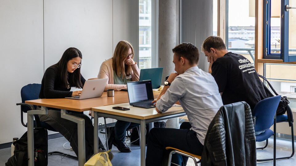 Vier Studierende bei der Arbeit an Laptops
