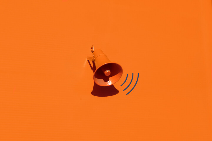 Ein Lautspracher auf knall-orangernem Hintergrund.